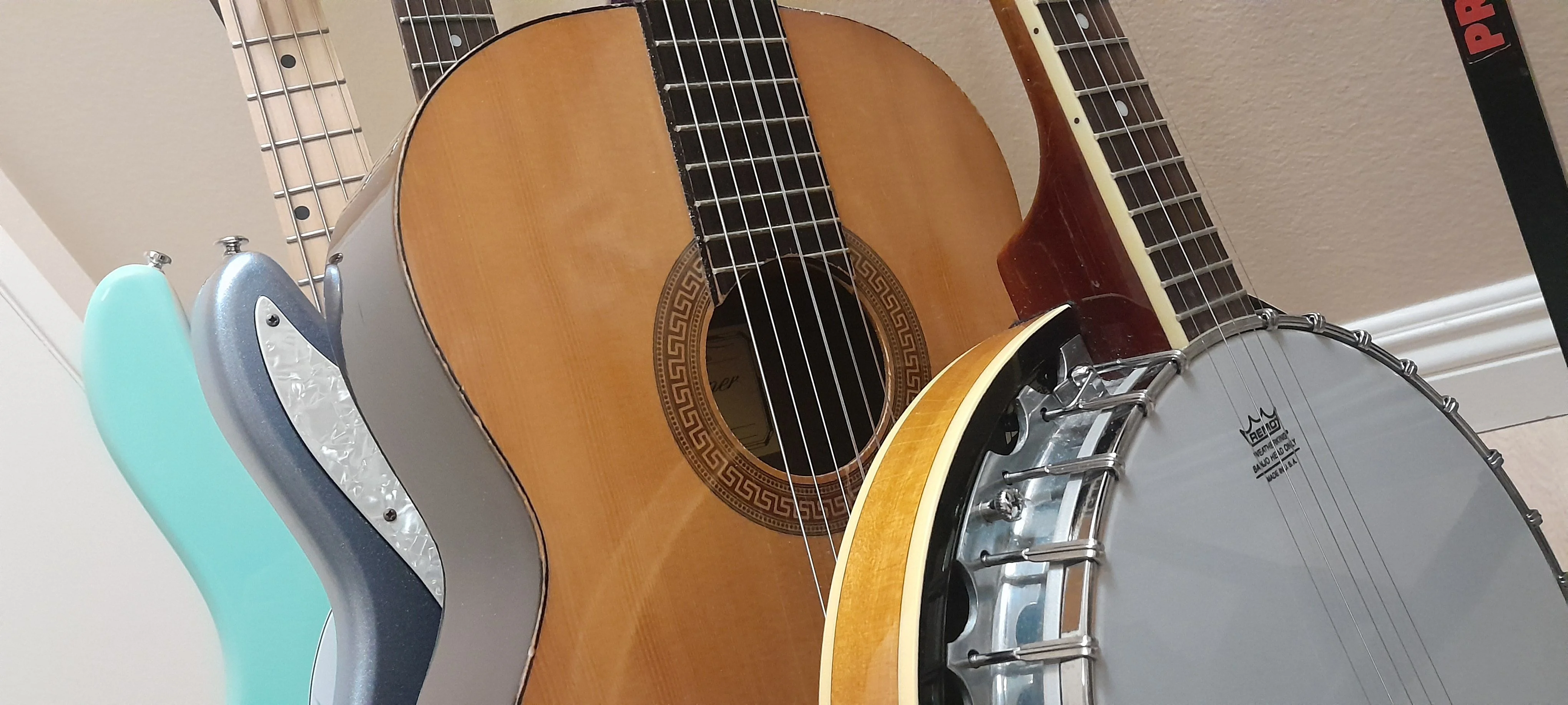 Collection of stringed instruments including bass, guitar, and banjo