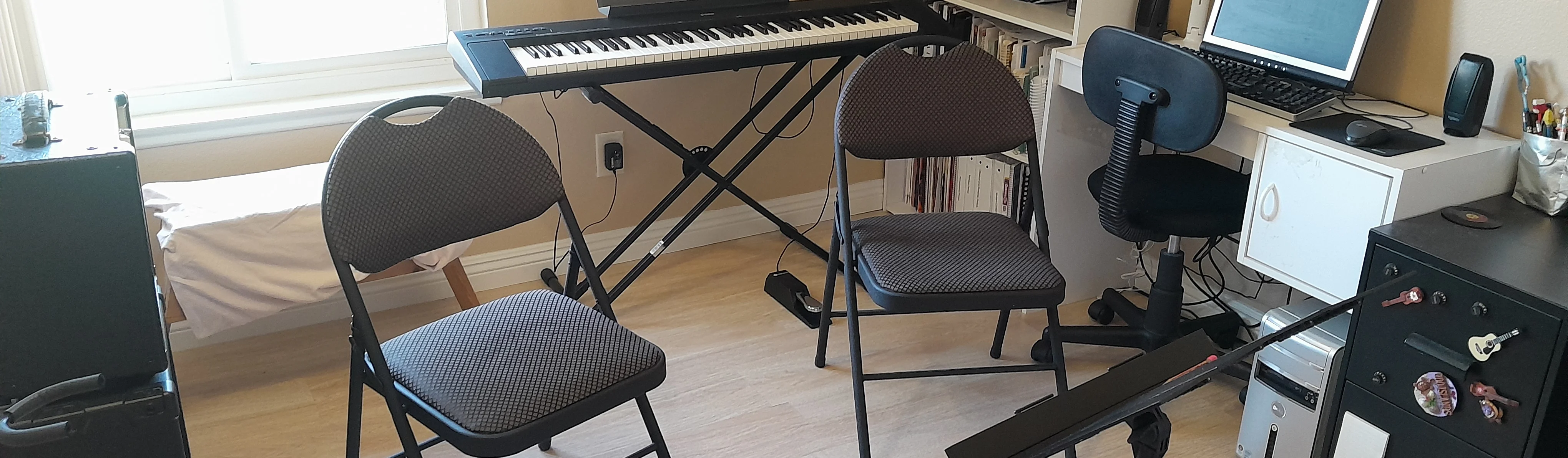 Private music lesson studio with music stand, chairs, and instrument cases